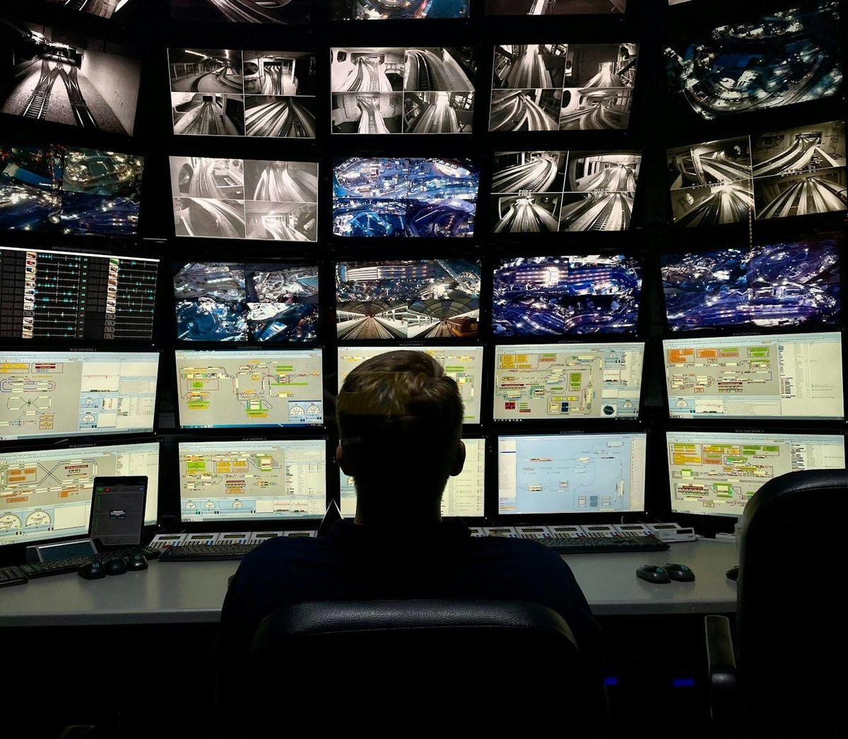 CCTV operator watching a wall of camera monitors