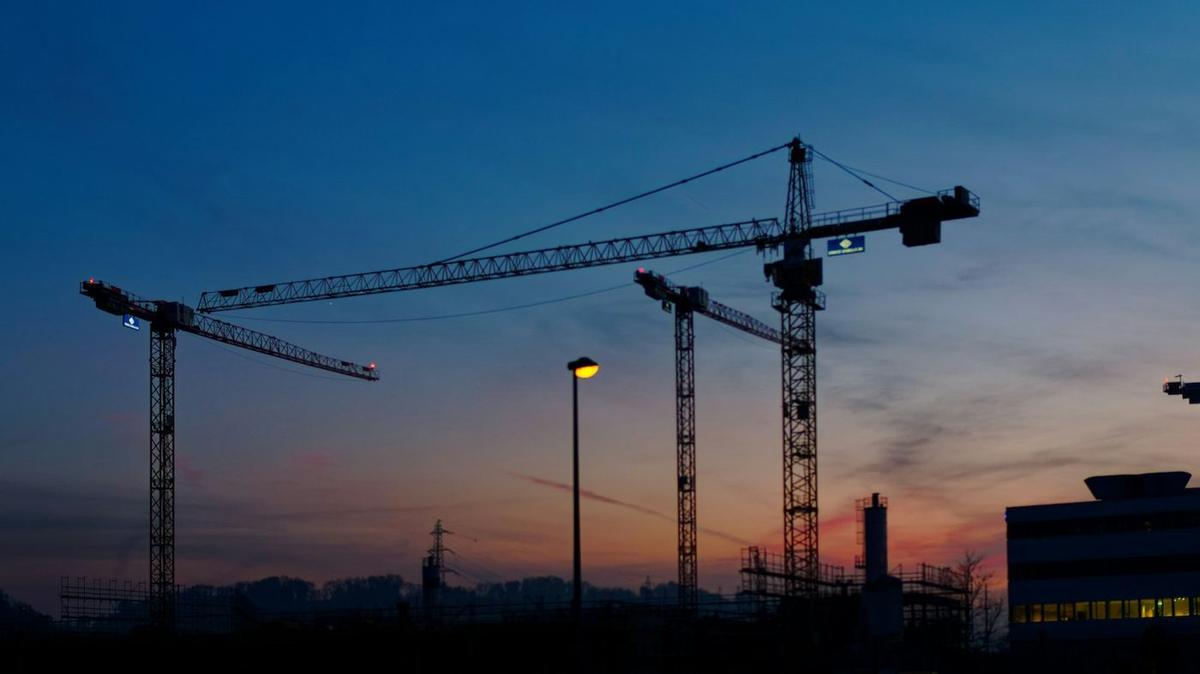 Construction site cranes at dusk