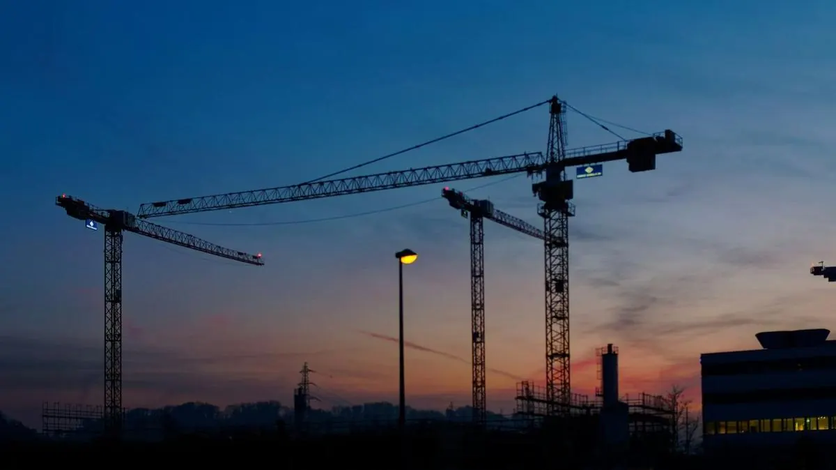 Construction site cranes at dusk